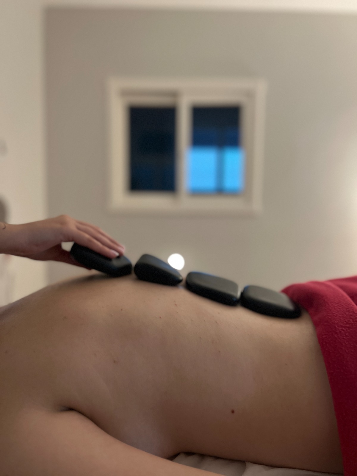 Pedras quentes posicionadas nas costas durante a massagem terapêutica.